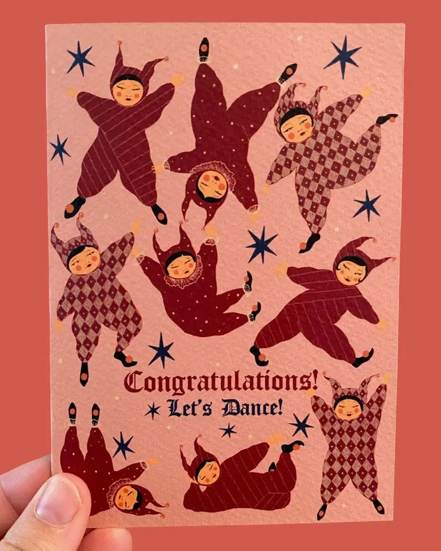Card with stylised illustrations of people in all-in-one suits and text 'Congratulations! Let's Dance!' on a pink background.