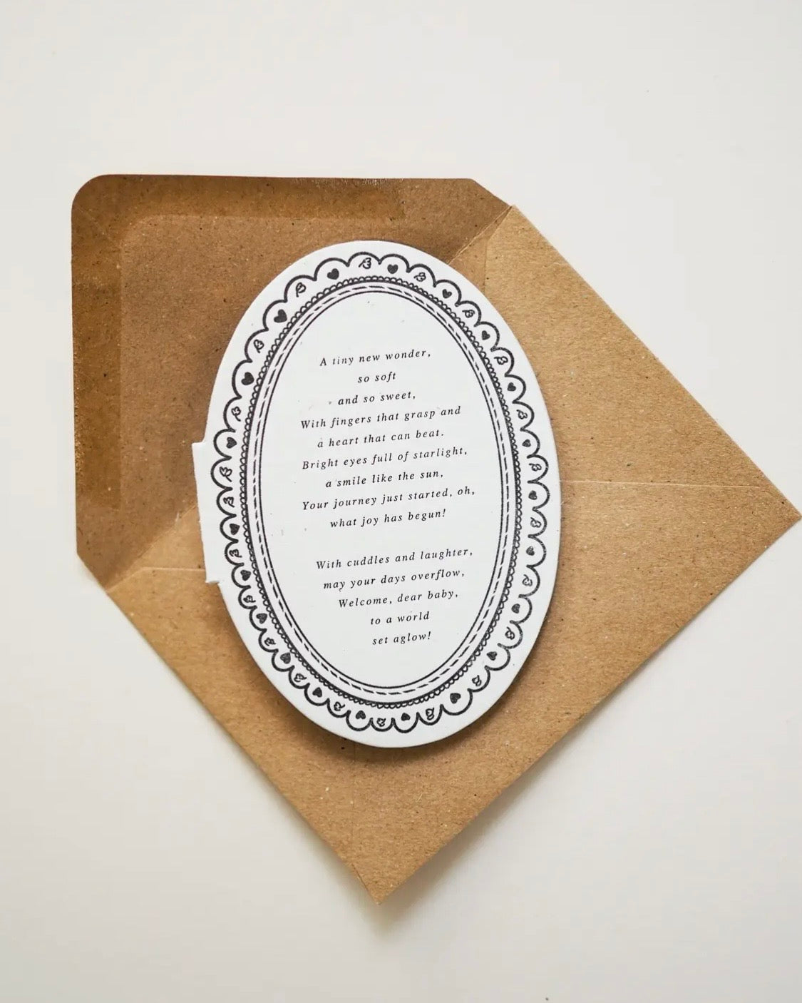 Decorative oval mini card with text on a kraft paper envelope