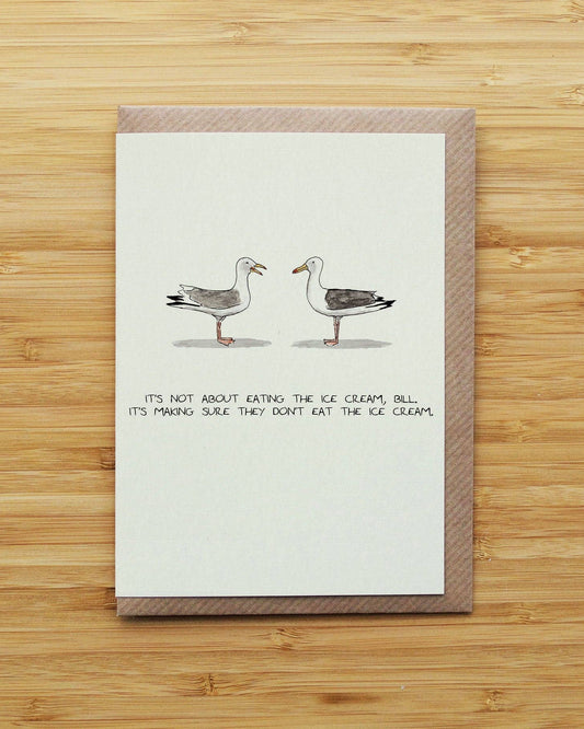 A greeting card with a brown envelope, featuring an illustration of two seagulls facing each other with the handwritten text: 'IT'S NOT ABOUT EATING THE ICE CREAM, BILL. IT'S MAKING SURE THEY DON'T EAT THE ICE CREAM.